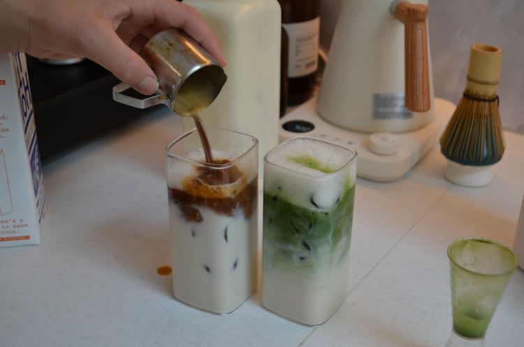 Iced matcha and iced coffee being poured